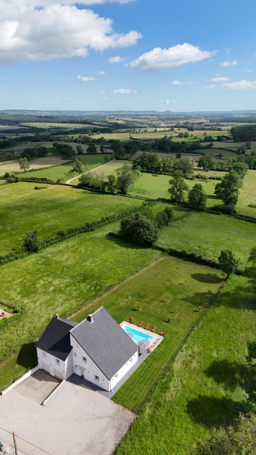 Vue aérienne d'un cottage blanc avec piscine chauffée dans la campagne verdoyante de Bourgogne, Magnien, France