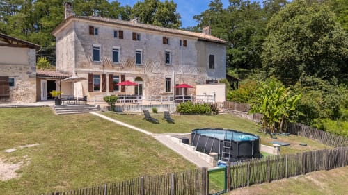 Cottage du Domaine de Pimpine à Galgon avec piscine, terrasse, parasols rouges et vue sur la rivière