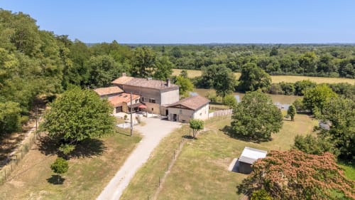 Vue aérienne du gîte Domaine de Pimpine à Galgon avec vue sur la rivière, entouré d'arbres et de jardins
