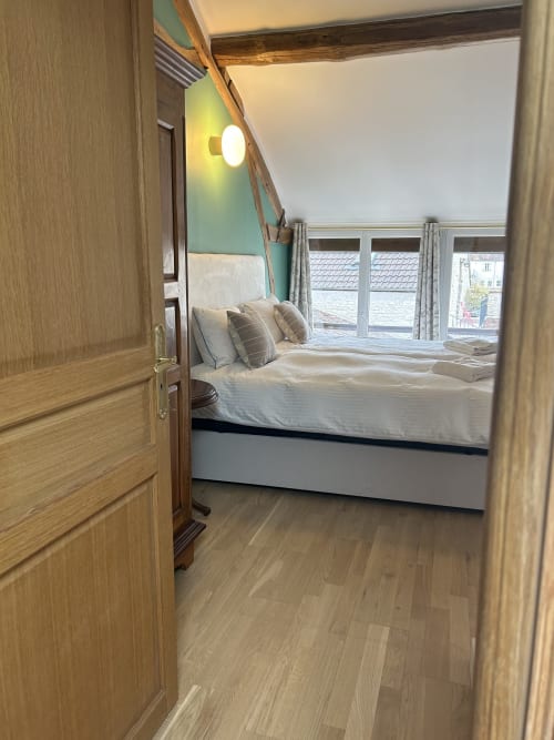 Chambre moderne au Domaine Chapelle B&B avec lit queen, tête de lit vert menthe, parquet et vue sur le jardin
