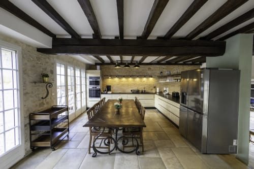 Cuisine spacieuse et salle à manger au Domaine Chapelle avec poutres apparentes, table de repas et électroménagers modernes