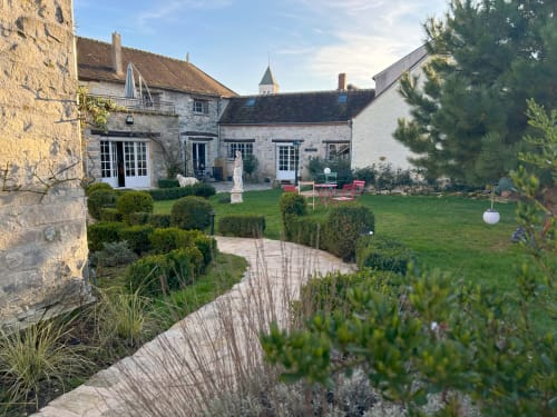 Jardin de manoir en pierre du Domaine Chapelle B&B à La Chapelle-la-Reine avec haies taillées, pelouse et coin détente