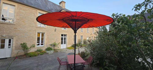 Parasol rouge avec table de repas et chaises à la maison d'hôtes Domaine de la Cour VAUTIER à Mandeville-en-Bessin, Normandie