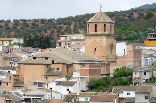Cúpula histórica de iglesia sobre edificios de terracota en Huelva, Jaén, España, mostrando la arquitectura tradicional andaluza