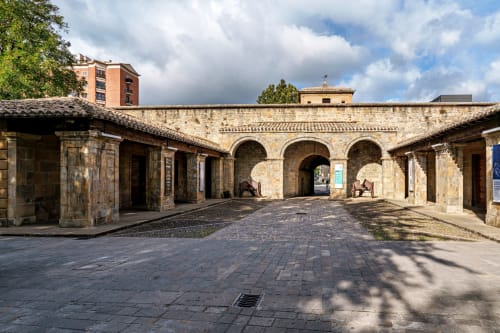 Patio histórico de piedra con arcos en Hostal Iruña Rooms en España, con arquitectura colonial y estilo tradicional