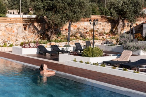 Mulher nadando na piscina do hotel Recantos D'Almerinda em Pombal com espreguiçadeiras e terraço de pedra