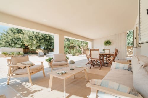 Spazioso soggiorno con vista sul giardino a Case Luparello a Noto, arredato con mobili in legno e poltrone confortevoli