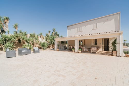 Appartamento moderno con terrazza a Case Luparello, Noto. Patio beige, palme, veranda arredata, cielo limpido.