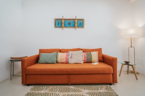 Divano arancione con cuscini decorativi nell'appartamento Biancolilla presso Case Luparello, Noto