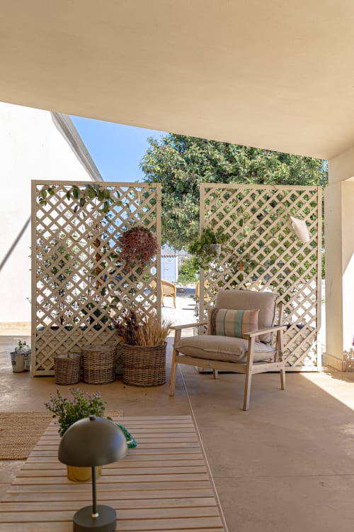 Veranda coperta con schermi a traliccio presso Case Luparello, Noto, con poltrona e piante in vaso