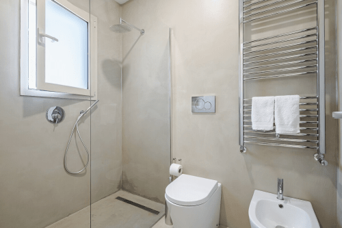 Bagno moderno con doccia a pioggia, scaldasalviette e finiture bianche presso l'appartamento Case Luparello a Noto, Sicilia