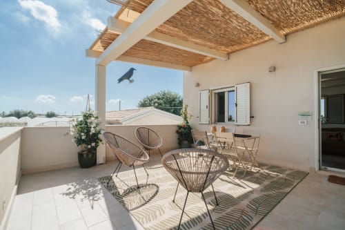 Terrazza dell'appartamento Moresca a Case Luparello, Noto con sedie intrecciate e pergolato