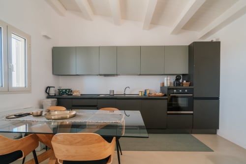 Cucina moderna dell'appartamento Moresca a Case Luparello a Noto con mobili scuri e zona pranzo