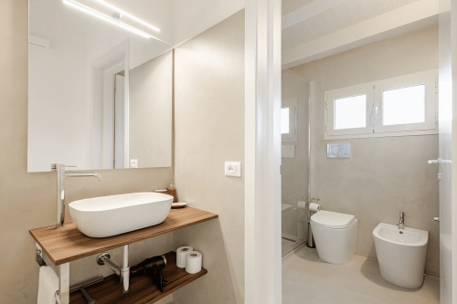 Bagno moderno dell'appartamento Moresca presso l'hotel Case Luparello a Noto, con lavabo, wc, bidet e doccia