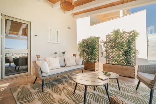 Elegante zona living dell'appartamento a Case Luparello Noto con vista sul giardino, arredamento contemporaneo, divano moderno e tavolino in legno