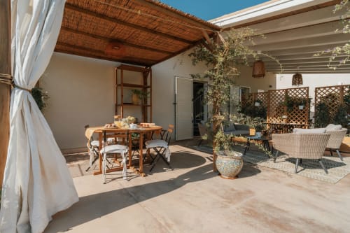 Terrazza dell'appartamento Carolea a Case Luparello a Noto, Sicilia con tavolo da pranzo, salotto e vista sul giardino sotto struttura in legno