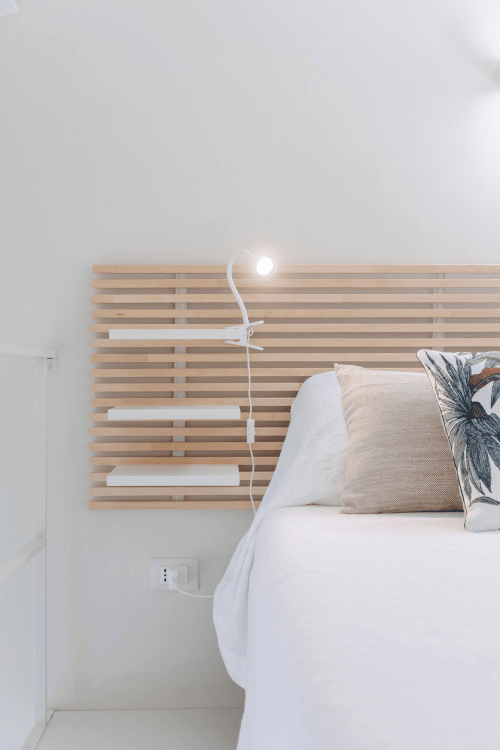 Camera da letto moderna a Case Luparello, Noto, con testata in legno a doghe e lampada da lettura