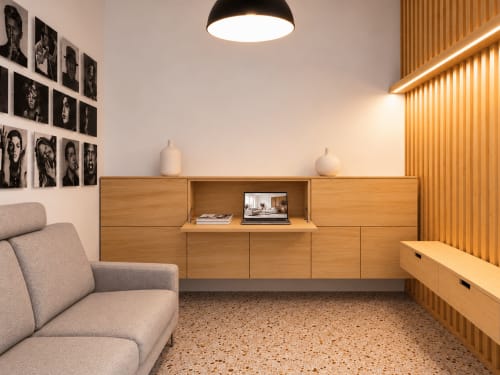 Camera moderna all'Easystay Bari con scrivania in legno, divano grigio, illuminazione a sospensione e pavimento in terrazzo a Bari, Italia
