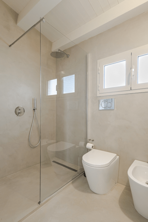 Bagno moderno nell'appartamento Carolea di Case Luparello a Noto, con doccia walk-in e finiture bianche