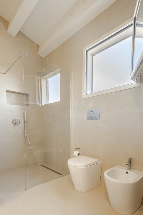 Bagno moderno dell'appartamento Carolea a Case Luparello, Noto con doccia in vetro, WC, bidet e lucernario