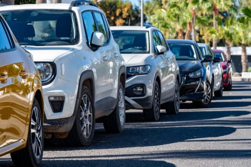 Fila de autos estacionados en el soleado estacionamiento del Hotel La Muntanya, Llafranc, España