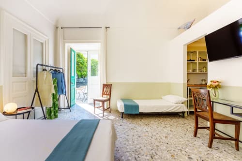 Ampia camera da letto presso il B&B Oliveri 25 a Procida con due letti, vista sul mare, TV e comfort moderni