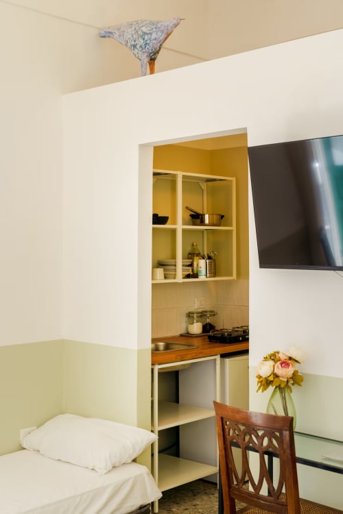 Camera da letto dell'appartamento B&B Oliveri 25 a Procida con angolo cottura, TV e vista sul mare