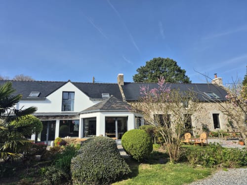 Vue extérieure de la maison d’hôtes Ty Coz Breizh à Guidel, en Bretagne Sud, avec sa façade en pierre, son jardin fleuri et ses espaces de détente. 