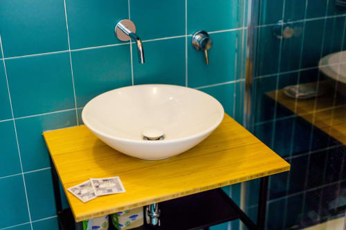 Lavabo bianco moderno su vanity gialla, parete in piastrelle turchesi presso B&B Oliveri 25, Procida