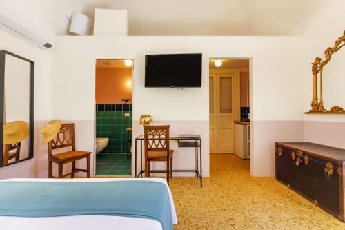 Camera da letto dell'appartamento B&B Oliveri 25 a Procida con TV, mobili in legno, pavimento in sughero e accesso al bagno