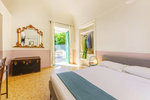 Camera luminosa con vista mare a B&B Oliveri 25 a Procida, letto bianco, pavimento in sughero e accesso al balcone