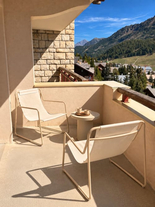 Balcon ensoleillé avec fauteuils crème et vue sur les montagnes aux Tanières de Montgenèvre