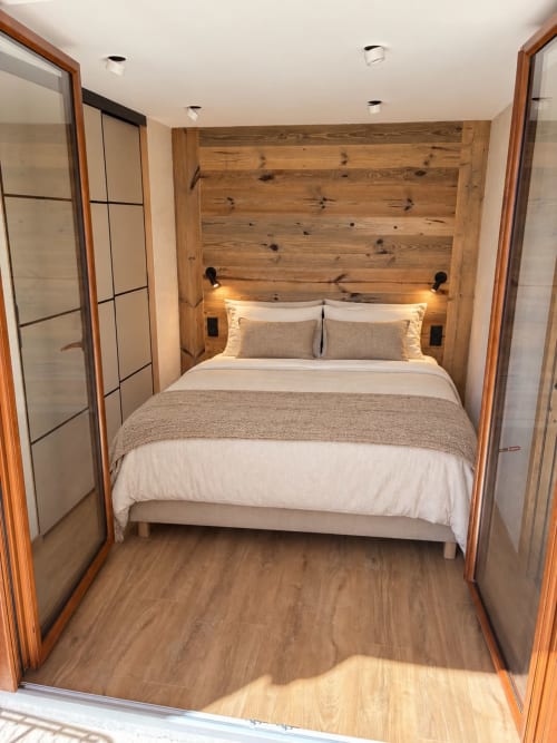 Chambre cosy aux Tanières de Montgenèvre avec tête de lit en bois, literie blanche et décoration épurée en appartement montagnard