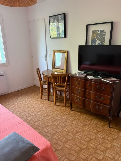 Le Meix guest room in Chaumergy with wooden furniture, TV, desk, and patterned carpet