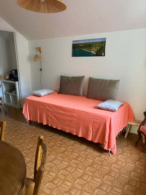 Spacious bedroom at Chambres d'hôtes Du 7 in Chaumergy with coral bedspread, taupe pillows, wooden furniture, and landscape