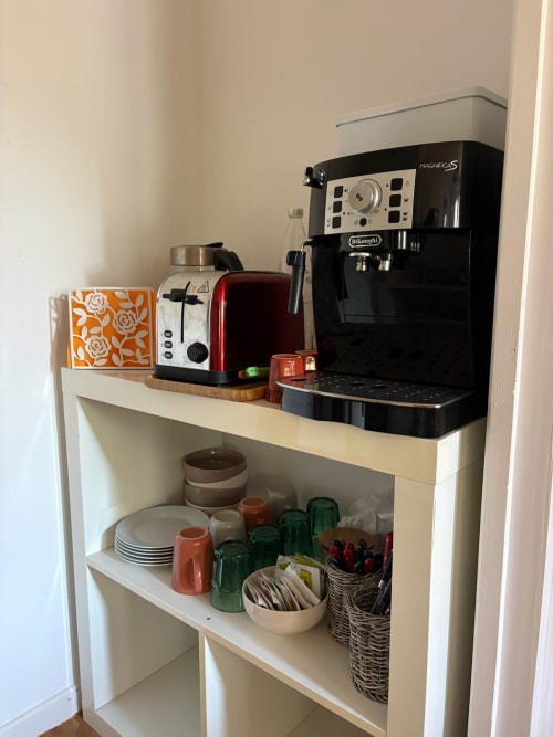 Coffee station with DeLonghi machine, toaster, and kitchenware in Le Meix room
