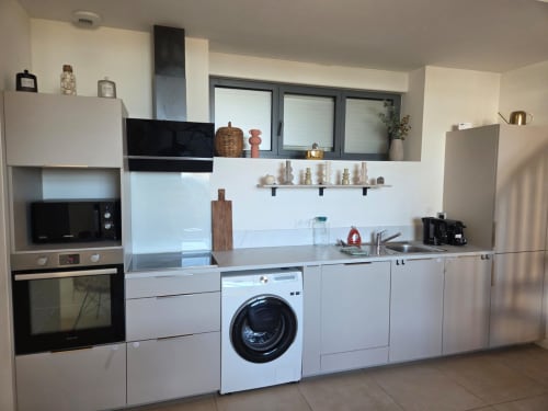 Cocina moderna en el apartamento La Perle du Léman en NN Patrimoine, Douvaine, con gabinetes blancos, lavadora y equipamiento completo