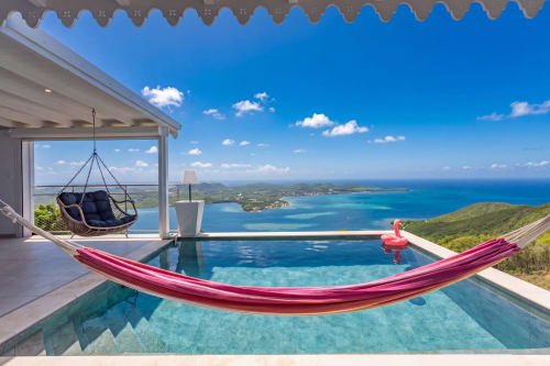 Piscine à débordement avec hamac rose dominant les eaux turquoise des Caraïbes à Villa Nid des Colibris, Martinique