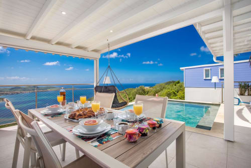 Villa Terrasses du Morne Gommier avec table de petit-déjeuner, vue océan, piscine et paysage tropical à Marin