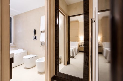 Camera Deluxe Maison Candia a Roma con bagno moderno, toilet e vista della camera da letto attraverso porte in vetro