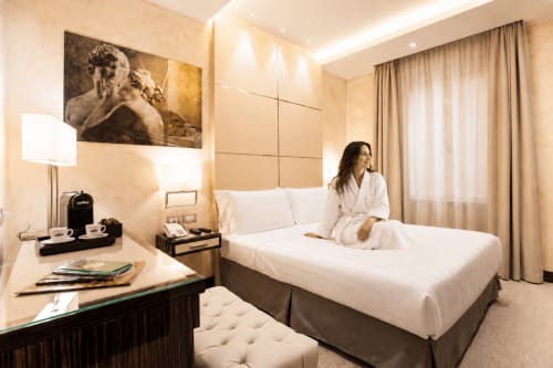 Modern hotel room at Maison Candia in Rome with queen bed, work desk, city view, and contemporary design