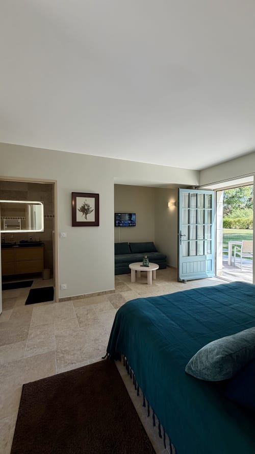 Chambre La Forêt au Cloffy B&B avec vue jardin, lit, salle de bain, salon et accès à la terrasse