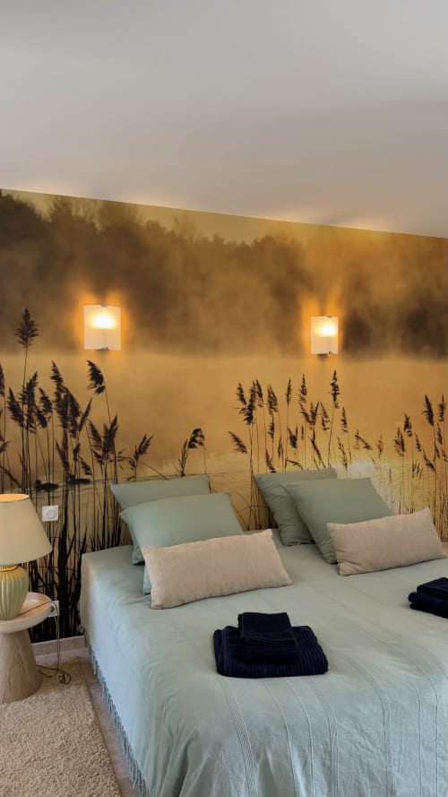 Chambre de la maison d'hôtes Cloffy à Nouans-les-Fontaines avec fresque murale artistique en roseaux, appliques murales et mobilier contemporain