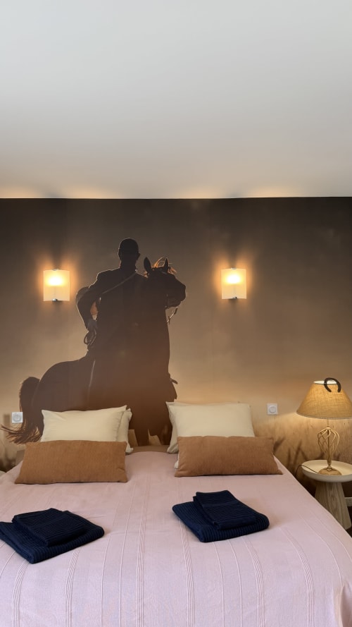 Fresque murale équestre dans la suite Vénerie de l'hôtel Cloffy à Nouans-les-Fontaines, avec literie luxueuse et éclairage ambiant