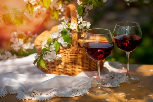 Red wine glasses and white flowering branch in wicker basket at L'Echappée Baie, Roz-sur-Couesnon