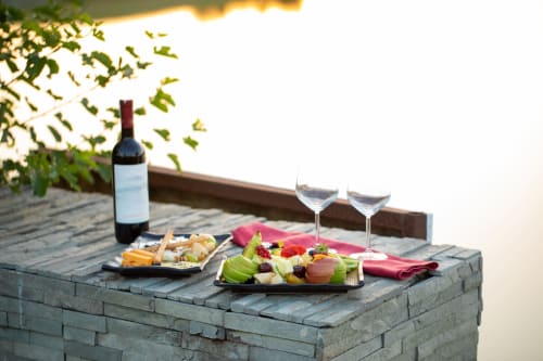 Wine and charcuterie board at L'Echappée Baie B&B in Roz-sur-Couesnon, with glasses and sunset view