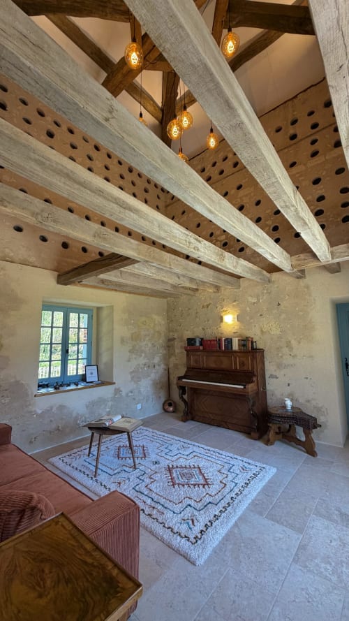 Rustic room at Cloffy B&B in Nouans-les-Fontaines with exposed beams, piano, and pendant lights