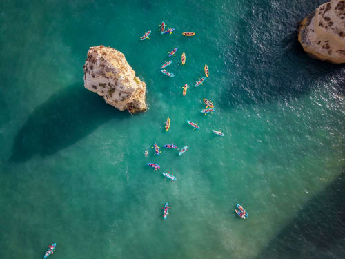 Vista aérea de kayaks coloridos en agua turquesa cerca de formaciones rocosas en la costa de Llafranc