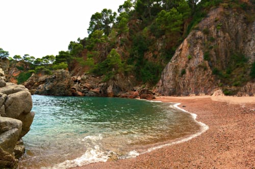 Cala recóndita del Hotel La Muntanya en Llafranc con aguas turquesas, playa de guijarros y acantilados espectaculares