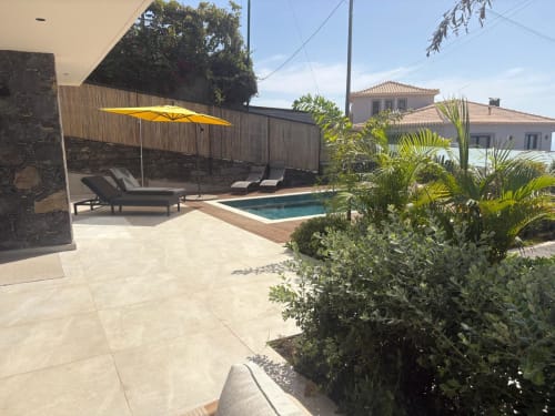 Luxuosa villa familiar nas residências BHF com piscina, espreguiçadeiras, guarda-sol amarelo, deck de madeira e jardim ajardinado em Arco da